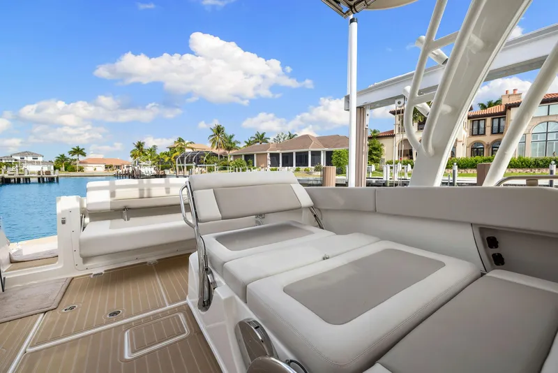 Slide: The Image of 2022 Boston Whaler 320 Vantage boat interior with luxurious seating, docked by waterfront homes. - 23