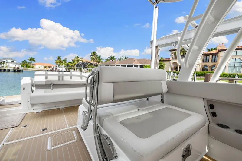 Slide: The Image of 2022 Boston Whaler 320 Vantage boat interior with luxurious seating and scenic waterfront view. - 24