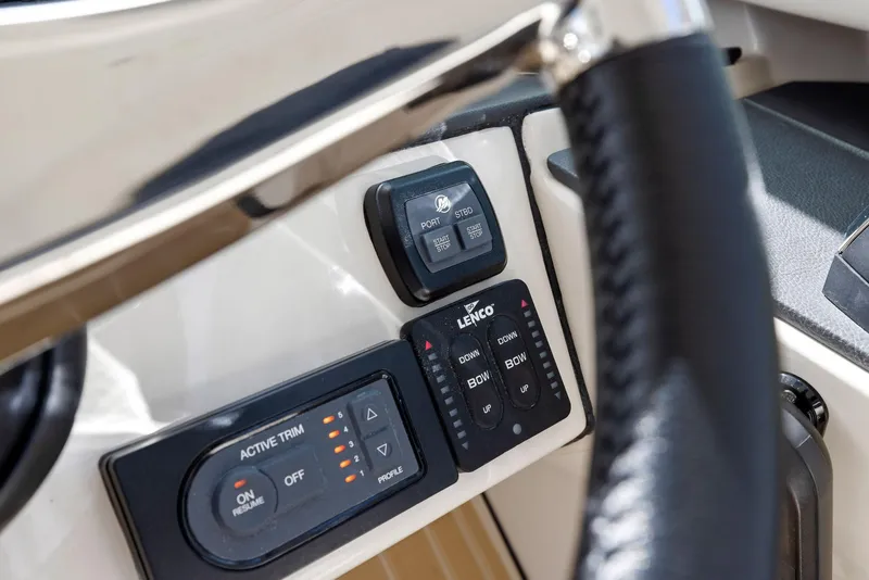 Slide: The Image of Control panel of 2022 Boston Whaler 320 Vantage boat, featuring trim and Lenco controls. - 33