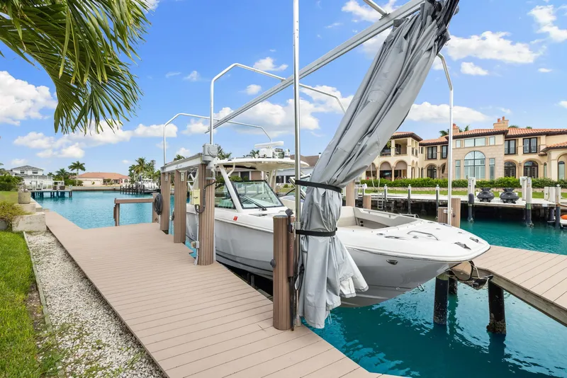 Slide: The Image of 2022 Boston Whaler 320 Vantage docked in a scenic waterfront setting. - 4