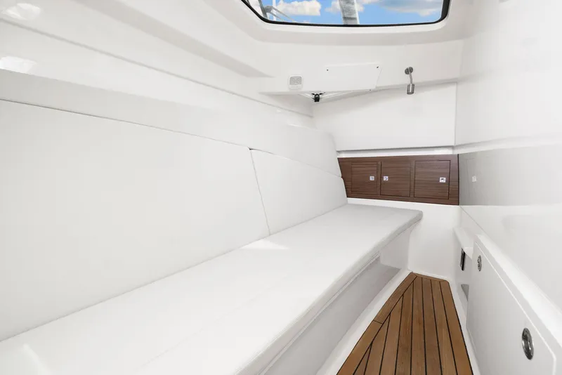 Slide: The Image of Interior of 2022 Boston Whaler 320 Vantage boat, featuring sleek white seating and wooden flooring. - 40