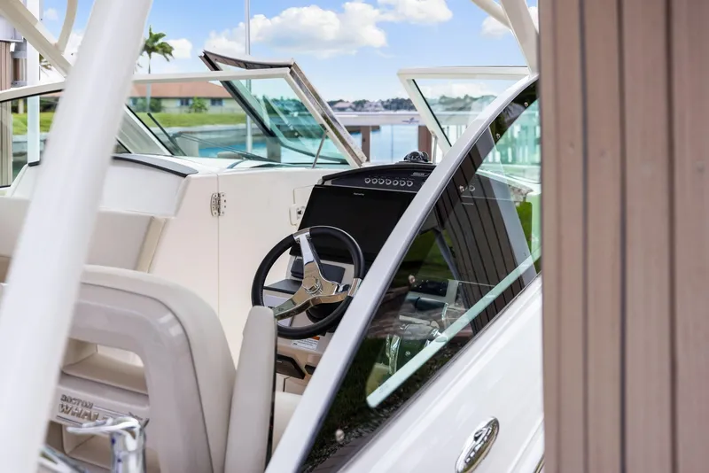 Slide: The Image of 2022 Boston Whaler 320 Vantage boat interior with steering wheel and open windshield. - 44