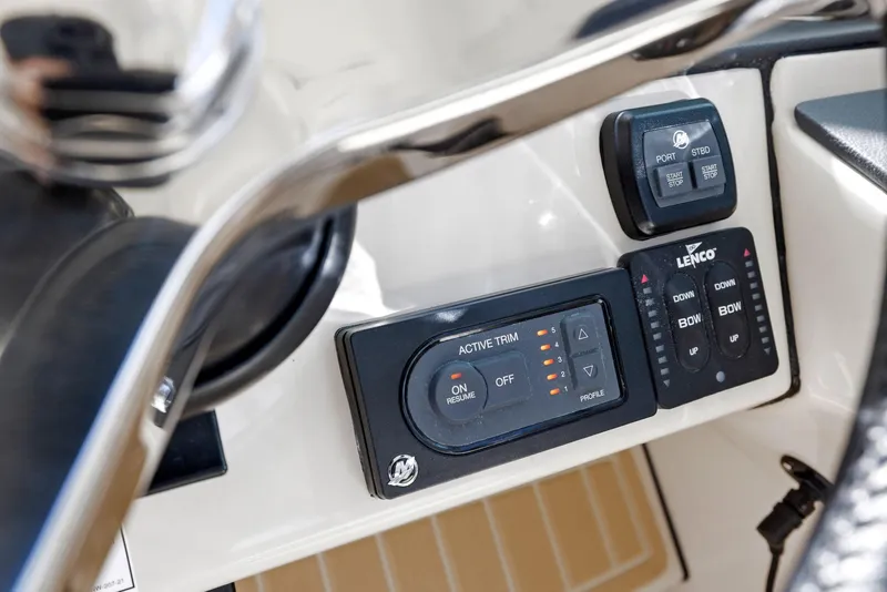 Slide: The Image of Control panel of 2022 Boston Whaler 320 Vantage boat, featuring trim and Lenco controls. - 46
