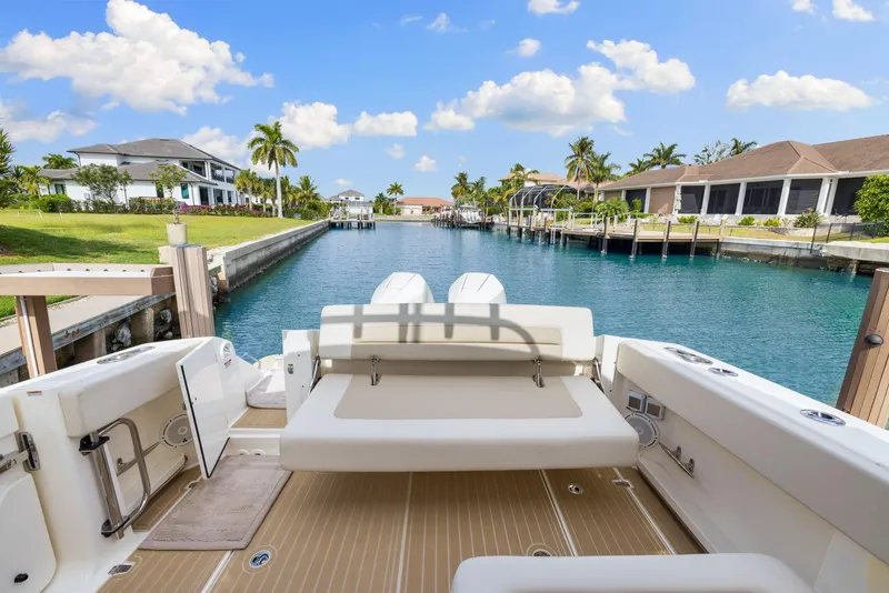 Slide: The Image of 2022 Boston Whaler 320 Vantage boat docked in a scenic canal with waterfront homes. - 48
