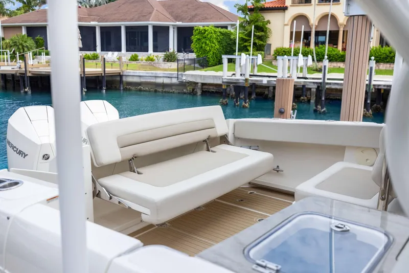 Slide: The Image of 2022 Boston Whaler 320 Vantage boat interior with seating, docked by waterfront homes. - 49