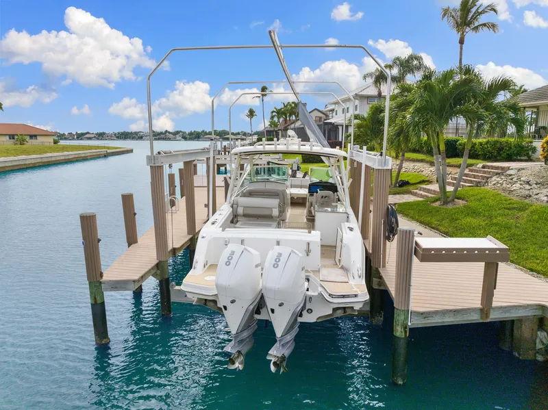 Slide: The Image of 2022 Boston Whaler 320 Vantage docked by a scenic waterfront with palm trees. - 7