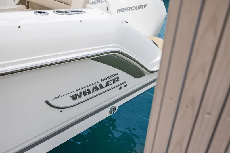 Slide: The Image of 2022 Boston Whaler 320 Vantage boat docked, featuring sleek design and Mercury engines. - 9
