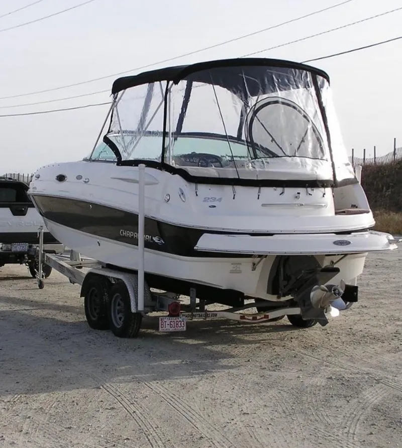 Slide: The Image of 2007 Chaparral Sunesta 234 boat on trailer with protective cover, parked outdoors. - 2