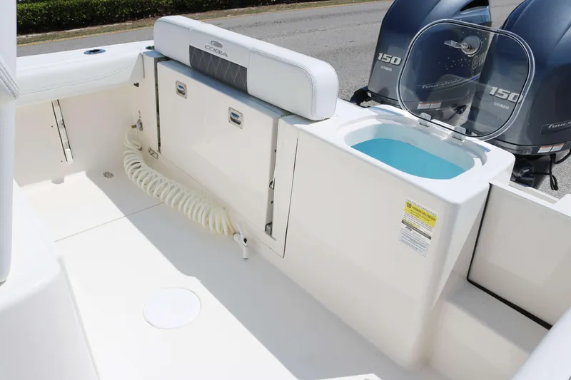Slide: The Image of 2023 Cobia 240 CC boat interior with livewell and twin engines. - 13