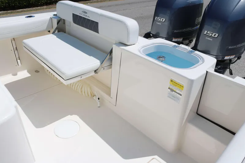 Slide: The Image of 2023 Cobia 240 CC boat interior with seating and dual outboard engines. - 14