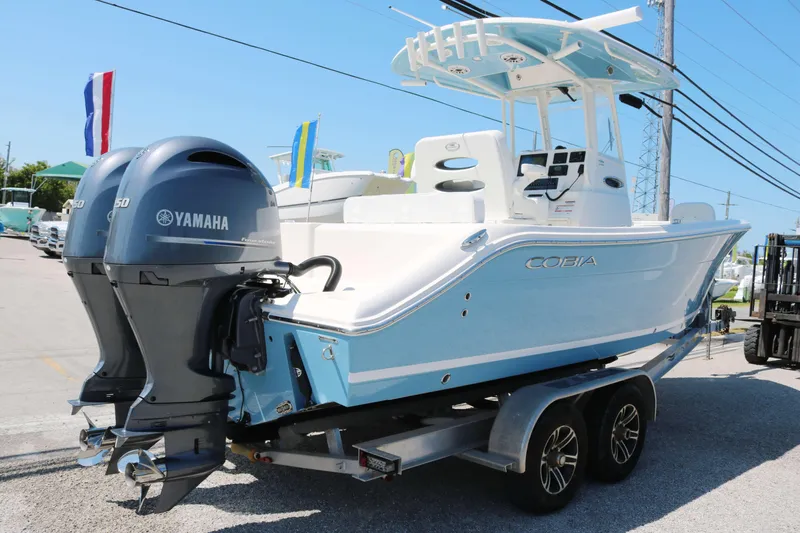 Slide: The Image of 2023 Cobia 240 CC boat with Yamaha engines on a trailer, displayed outdoors. - 3