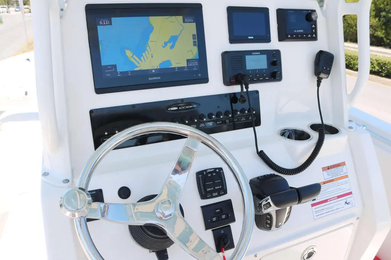 Slide: The Image of 2023 Cobia 240 CC boat dashboard with navigation and communication equipment. - 6