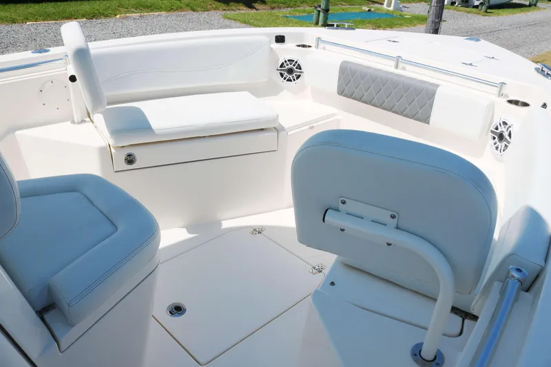 Slide: The Image of 2023 Cobia 240 CC boat interior with white seating and storage compartments. - 8