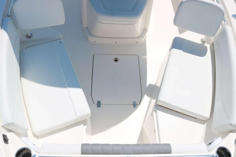 Slide: The Image of 2023 Cobia 240 CC boat interior with white seating and storage compartment. - 9