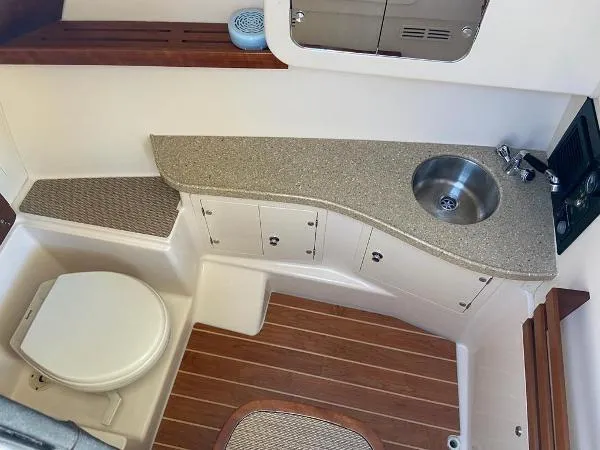 Slide: The Image of 2013 Grady-White Freedom 335 boat interior with sink, toilet, and wooden flooring. - 7