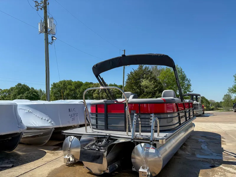 Slide: The Image of 2025 Trifecta 22RF CS pontoon boat with canopy, parked outdoors on a sunny day. - 2