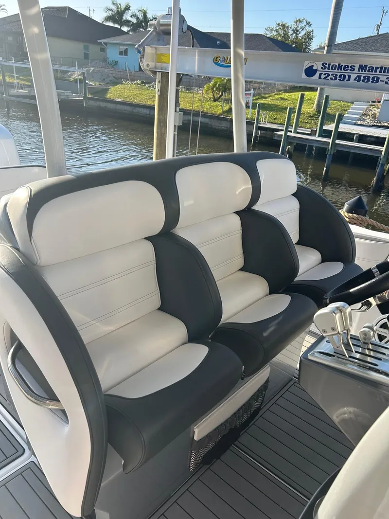 Slide: The Image of 2018 Nor-Tech 340 Sport boat with sleek, cushioned seating by the water. - 18