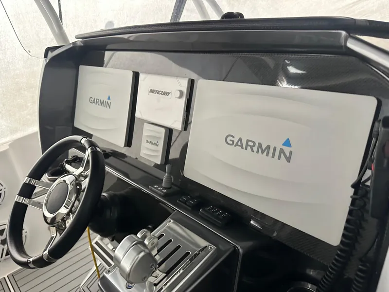 Slide: The Image of 2018 Nor-Tech 340 Sport boat dashboard with Garmin navigation displays and steering wheel. - 19