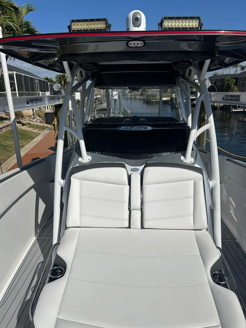 Slide: The Image of 2018 Nor-Tech 340 Sport boat with white seating and sleek design in a marina setting. - 21
