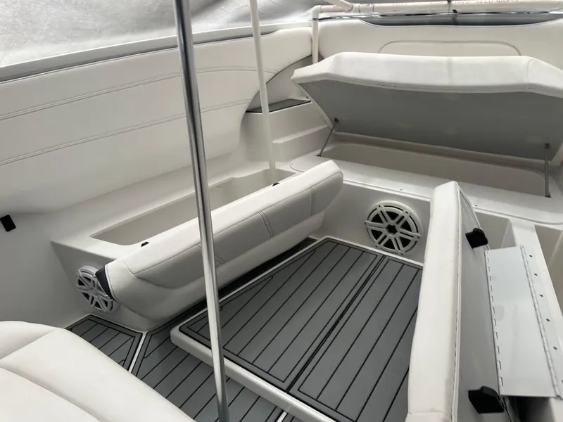 Slide: The Image of 2018 Nor-Tech 340 Sport boat interior with white seating and storage compartments. - 27