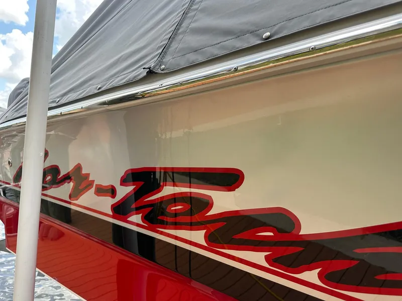 Slide: The Image of 2018 Nor-Tech 340 Sport boat with red and black graphics, docked under a cloudy sky. - 3