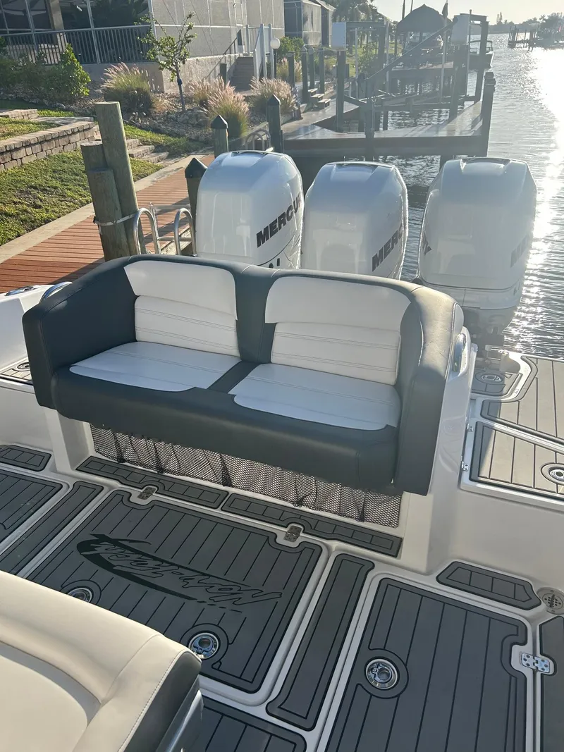 Slide: The Image of 2018 Nor-Tech 340 Sport boat with seating and Mercury engines docked by the water. - 7