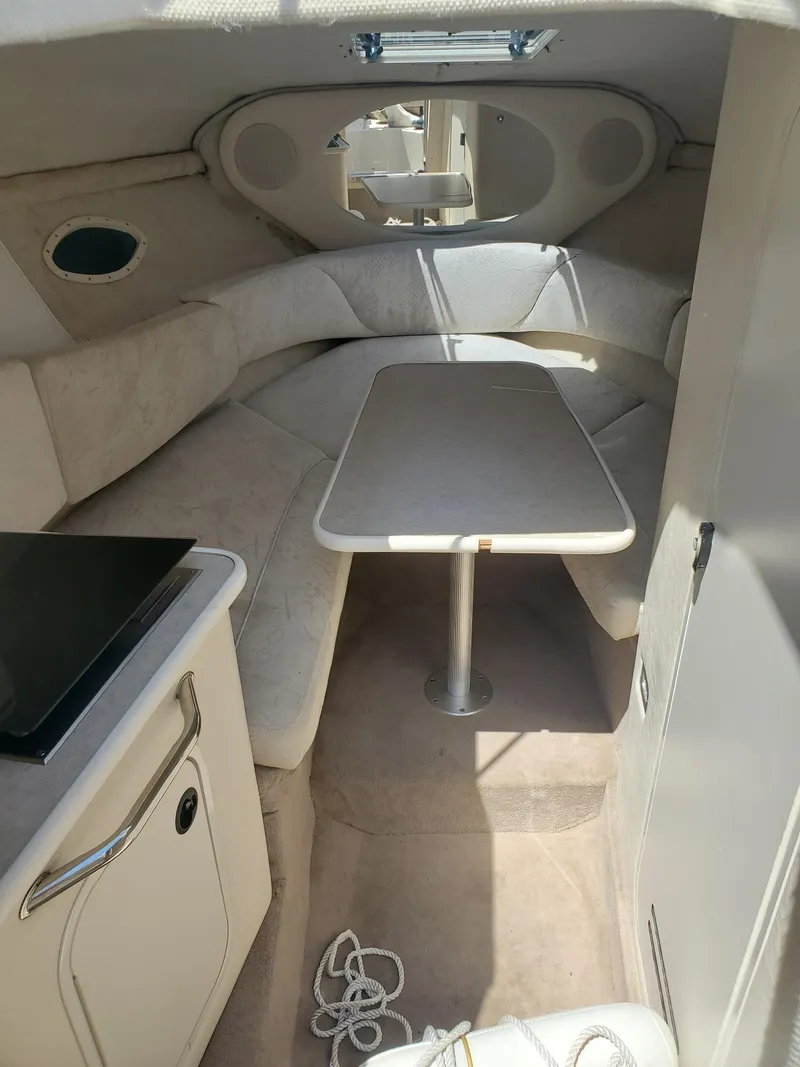 Slide: The Image of 2001 Sea Ray 245 Weekender cabin interior with seating and table. - 11