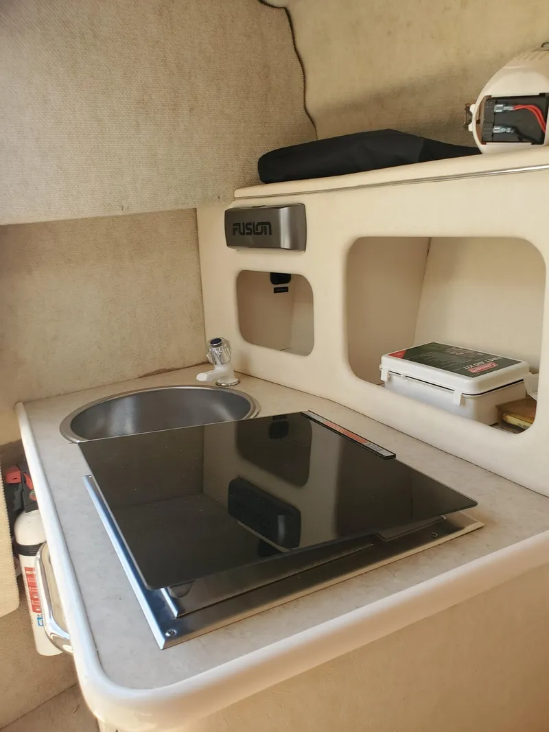 Slide: The Image of 2001 Sea Ray 245 Weekender boat interior with compact kitchenette and sink. - 12