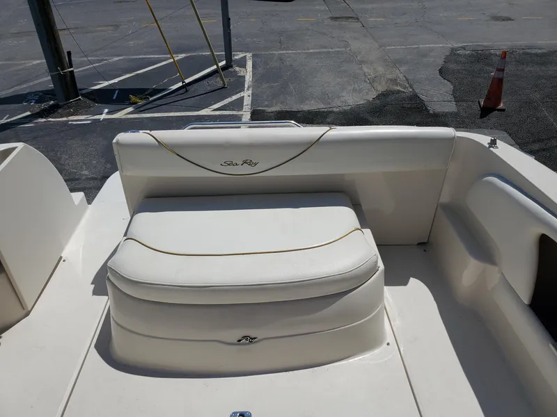 Slide: The Image of 2001 Sea Ray 245 Weekender boat interior with white seating and logo. - 13