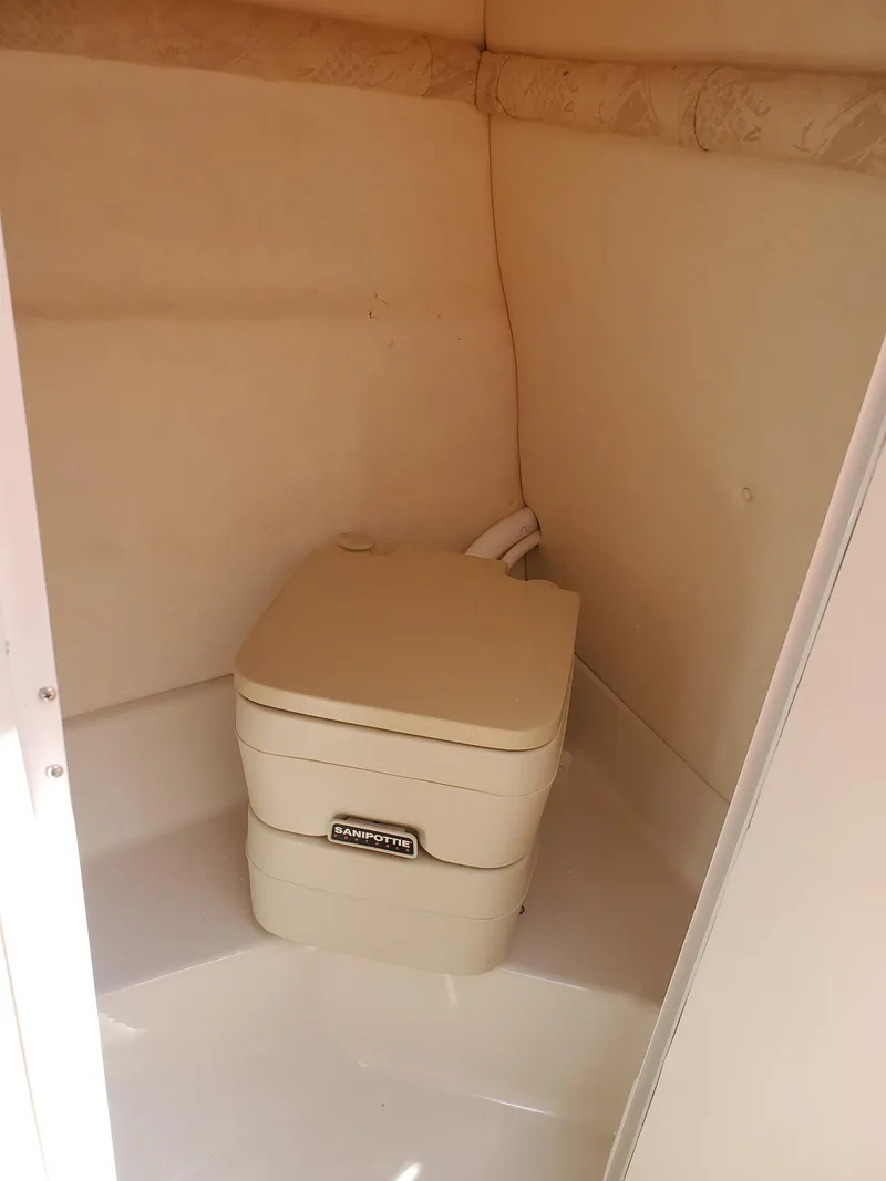 Slide: The Image of 2001 Sea Ray 245 Weekender boat interior with compact portable toilet. - 18