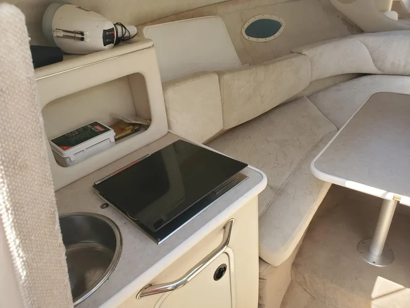 Slide: The Image of Interior of a 2001 Sea Ray 245 Weekender boat with kitchenette and seating area. - 9