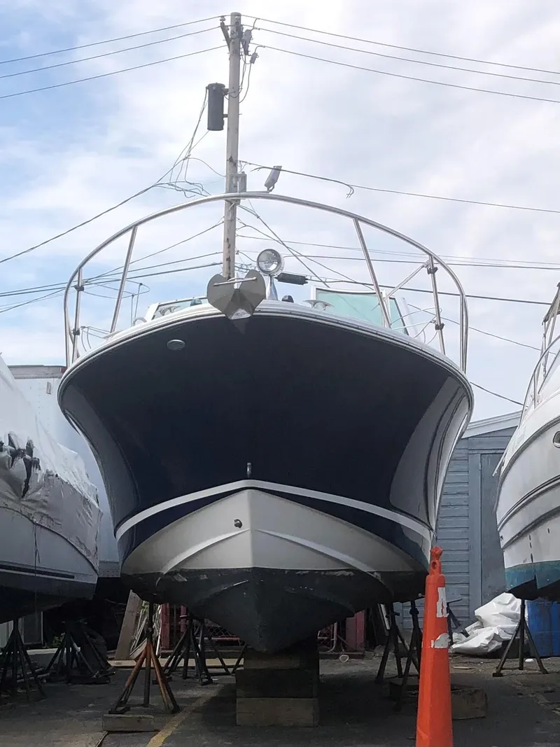 Slide: The Image of 2001 Chris-Craft 26 Constellation boat on dry dock, front view, with clear sky background. - 4