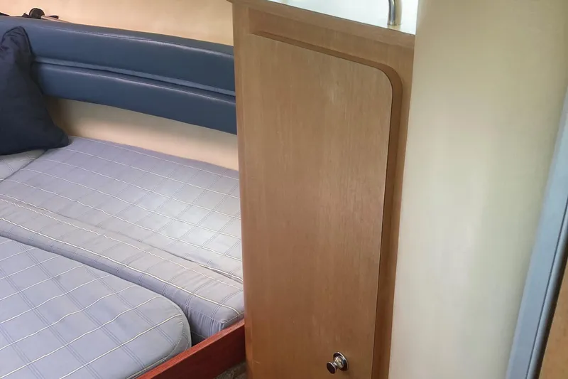 Slide: The Image of 2001 Chris-Craft 26 Constellation cabin interior with bed and wooden cabinet. - 7