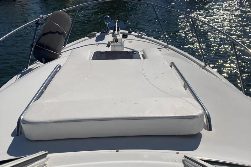 Slide: The Image of 2001 Chris-Craft 26 Constellation boat deck with sun pad and railing, on sparkling water. - 8