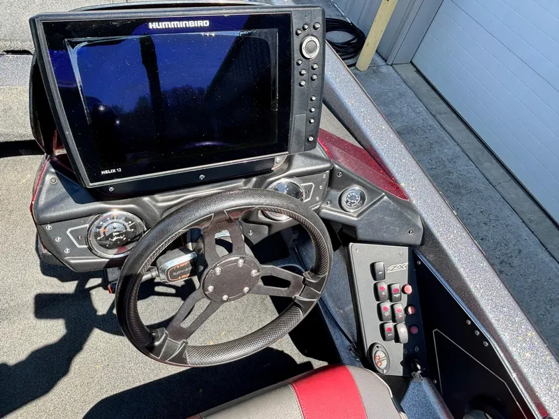Slide: The Image of 2019 Skeeter ZX 250 boat dashboard with steering wheel and Humminbird sonar display. - 9