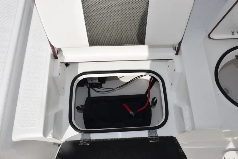 Slide: The Image of Open storage compartment in 2025 Frontier 2104 boat, showing battery and wiring. - 19