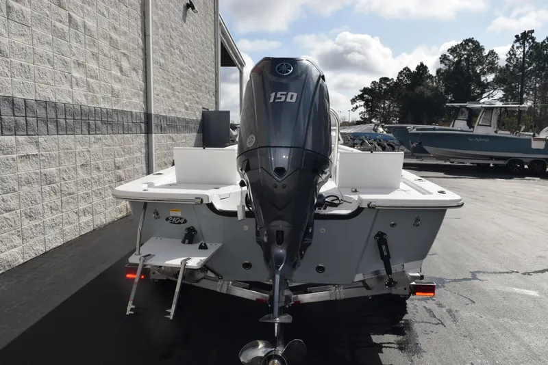 Slide: The Image of 2025 Frontier 2104 boat with 150 HP outboard motor, parked outdoors. - 5