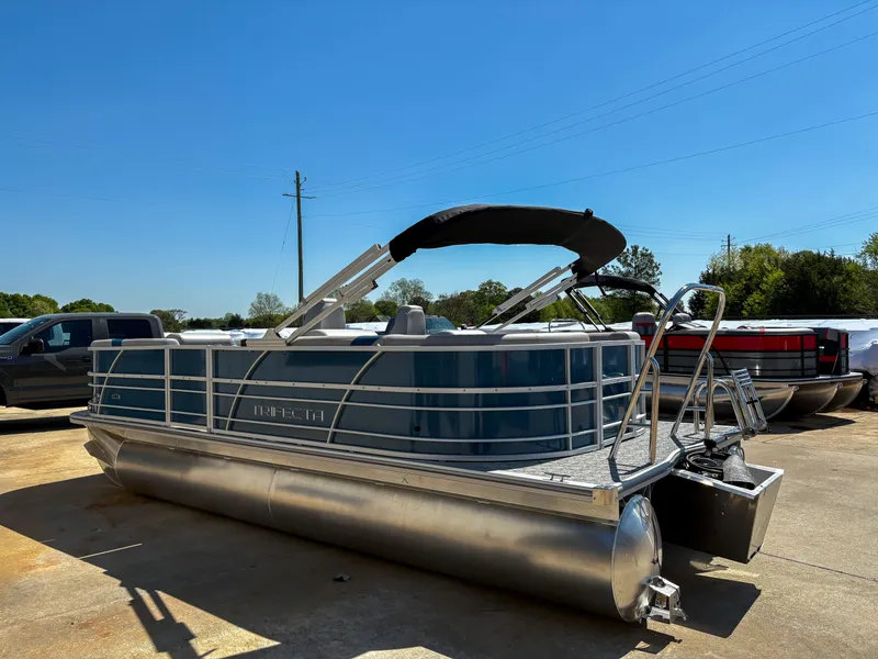 Slide: The Image of 2025 Trifecta 22 RF LE pontoon boat with blue exterior, docked outdoors under clear sky. - 3