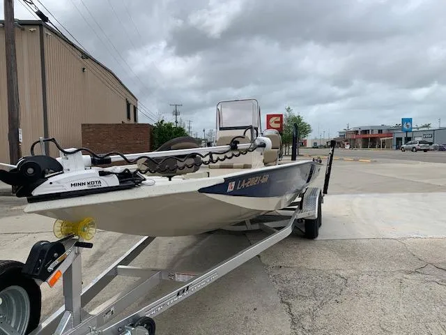 Slide: The Image of 2024 Xpress H22 boat on trailer, parked in an industrial area under cloudy skies. - 1