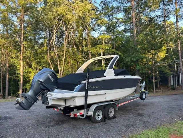 Slide: The Image of 2022 Chaparral 267 SSX OB boat on trailer, parked in wooded area. - 10