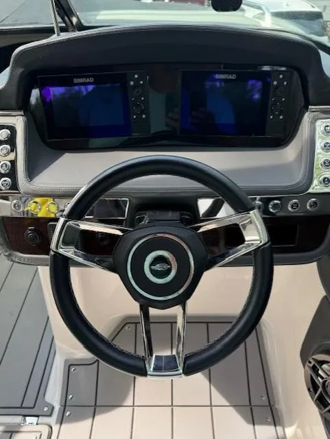 Slide: The Image of 2022 Chaparral 267 SSX OB boat dashboard with dual Simrad displays and modern steering wheel. - 3
