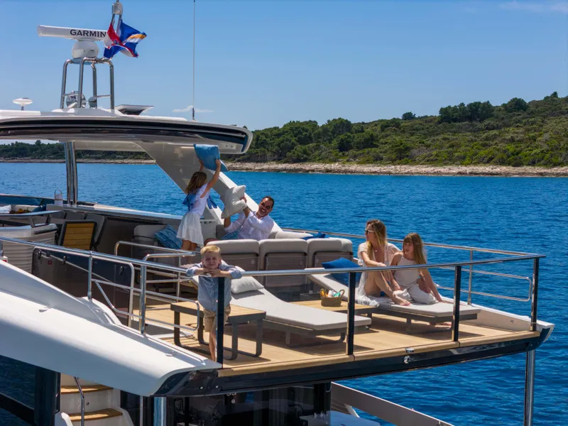 Slide: The Image of Family enjoying leisure time on 2026 Absolute Navetta Co Ownership yacht, anchored near scenic coastline. - 3