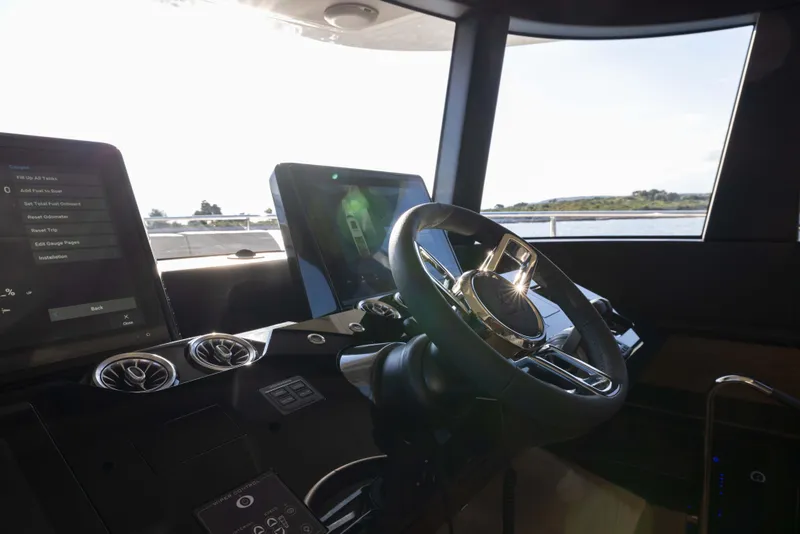 Slide: The Image of Steering wheel and dashboard of 2026 Absolute Navetta Co Ownership yacht, with scenic water view. - 47