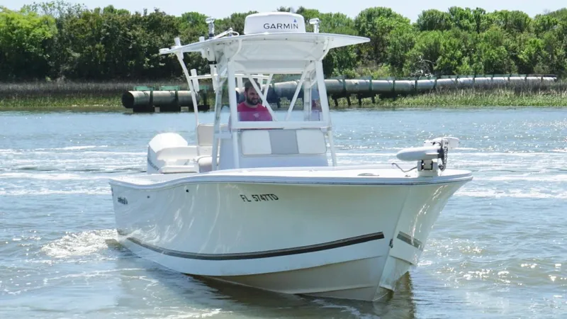 Slide: The Image of 2000 Regulator 26 Classic boat cruising on water with Garmin equipment, surrounded by greenery. - 11