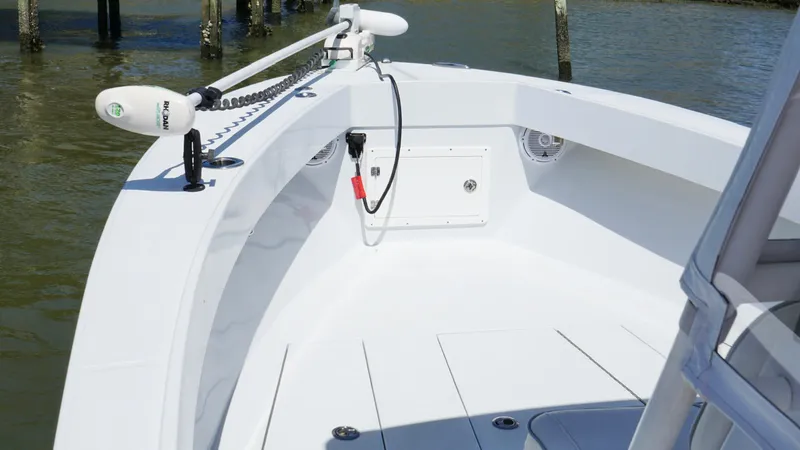 Slide: The Image of 2000 Regulator 26 Classic boat deck with trolling motor, docked on calm water. - 13
