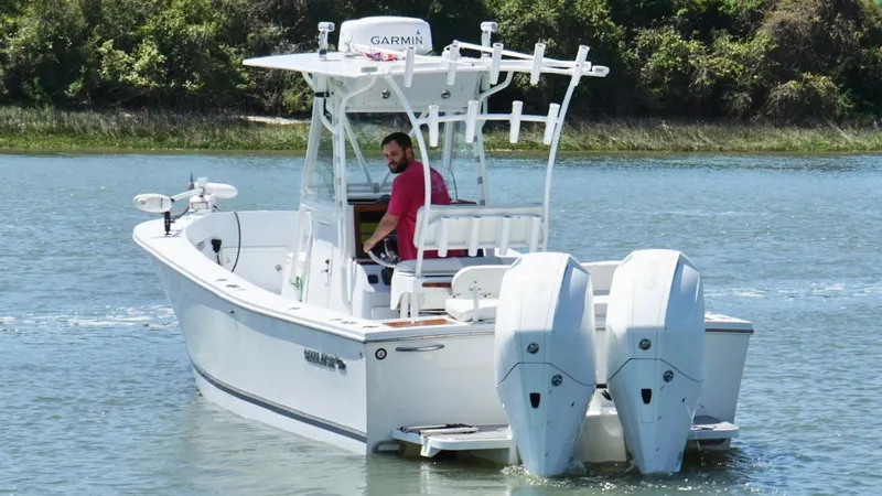Slide: The Image of 2000 Regulator 26 Classic boat with dual engines on a calm waterway. - 4