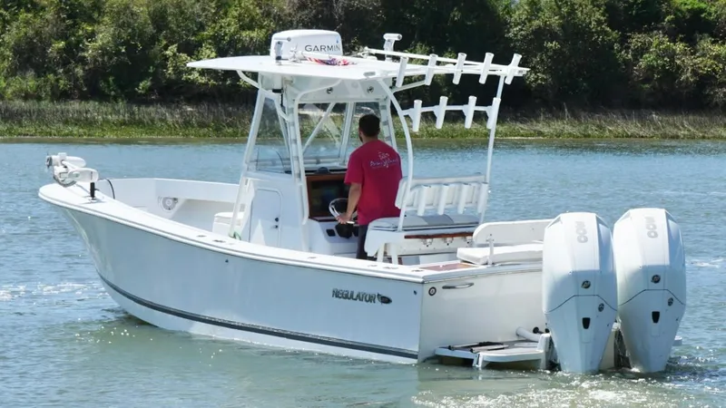 Slide: The Image of 2000 Regulator 26 Classic boat with dual engines cruising on a calm waterway. - 6