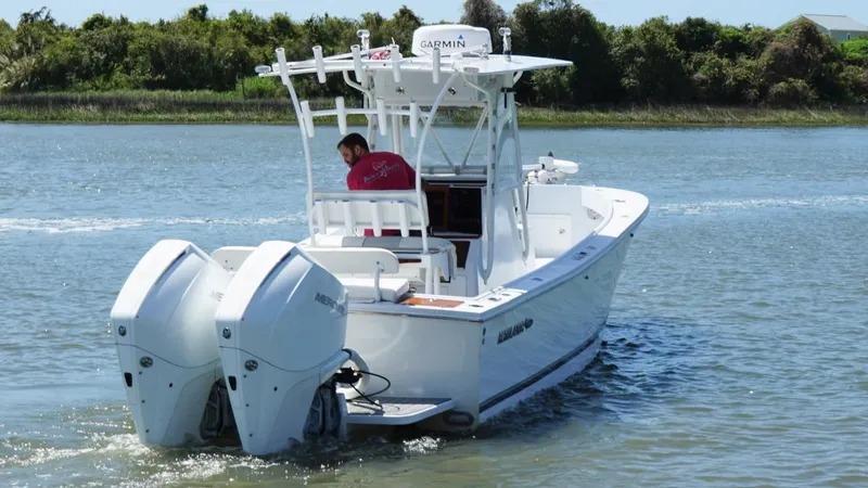 Slide: The Image of 2000 Regulator 26 Classic boat with dual engines cruising on a calm waterway. - 7