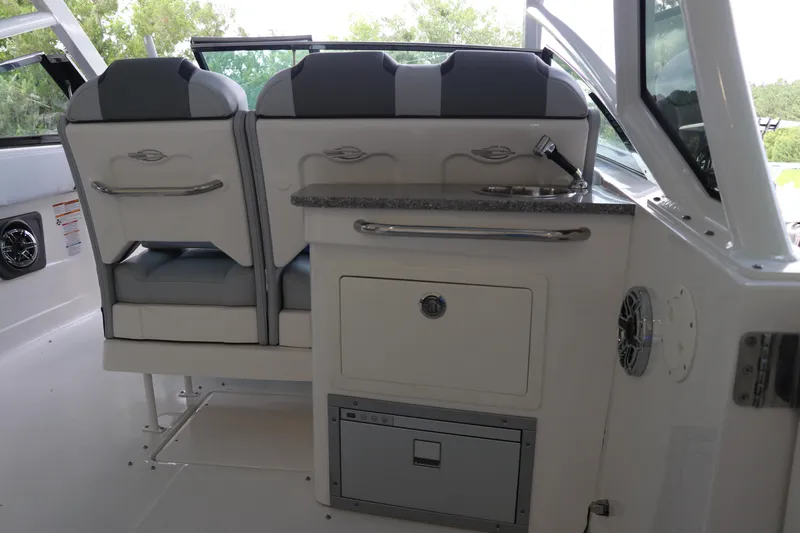 Slide: The Image of 2025 Chaparral 280 OSX boat interior with seating and kitchenette area. - 20