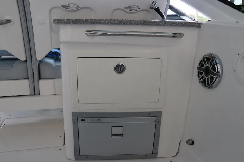 Slide: The Image of 2025 Chaparral 280 OSX boat interior with storage compartment and speaker. - 21